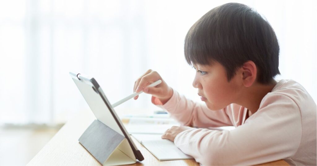タブレットで学習教材を使って勉強する子ども